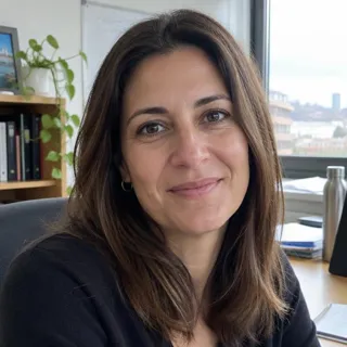 Marta Ribas sonriendo en su oficina con luz natural